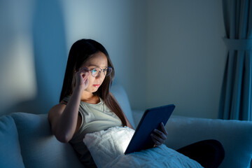 Poster - Woman with glasses and suffer from eye pain with use of digital tablet  in the evening at home