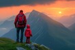 Adventurer and child in crimson, stand on peak, witnessing the sun dip below mountain silhouette. Two figures in red, gaze at sunset over alpine crests, a tranquil moment on highland vantage.