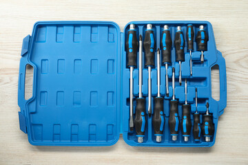 Sticker - Set of screwdrivers in open toolbox on light wooden table, top view