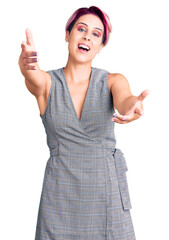 Wall Mural - Young beautiful woman with pink hair wearing casual clothes looking at the camera smiling with open arms for hug. cheerful expression embracing happiness.