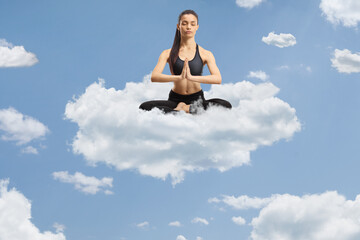 Canvas Print - Young female practicing meditation on a cloud