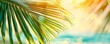 Beautifully blurred green palm leaf on a tropical beach with an abstract background of sun light waves.