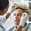 A medical professional is administering a botox injection to a male patient's forehead, showcasing a medical cosmetic procedure