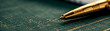 A pen is sitting on a green surface with a pattern on it. The pen is gold and has a black tip. Concept of focus and attention to detail, as the pen is placed precisely on the surface