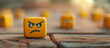 A single angry-faced emoji stands out on a wooden surface, surrounded by other indifferent or neutral faces.