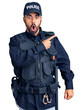 Young hispanic man wearing police uniform surprised pointing with finger to the side, open mouth amazed expression.