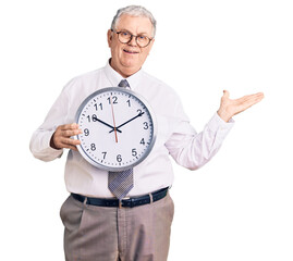 Wall Mural - Senior grey-haired man wearing business clothes and holding clock celebrating victory with happy smile and winner expression with raised hands