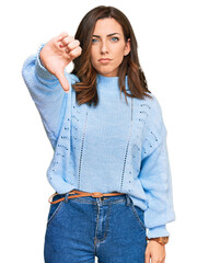 Sticker - Young brunette woman wearing casual winter sweater looking unhappy and angry showing rejection and negative with thumbs down gesture. bad expression.