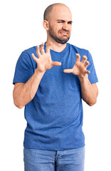 Wall Mural - Young handsome man wearing casual t shirt disgusted expression, displeased and fearful doing disgust face because aversion reaction. with hands raised