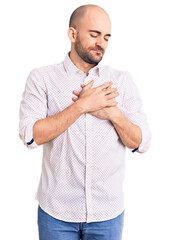 Canvas Print - Young handsome man wearing elegant shirt smiling with hands on chest with closed eyes and grateful gesture on face. health concept.