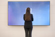 Young businesswoman analyzing data on large screen