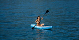 Fototapeta Panele - Beautiful young woman relaxing on paddle board in the summer lake or sea water. Luxury summer resort. Sexy sensual fit woman rest in water. Beautiful model enjoying summer travel vacation.