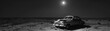 A vintage car abandoned in desolation, bathed in moonlight, captured in a haunting monochrome that speaks of times gone by