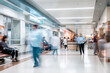 © Tigarto - Blurred Motion: Busy Hospital Hallway with Patients and Healthcare Professionals in Motion, Capturing the Dynamic Atmosphere of Medical Care