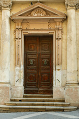 Wall Mural - Old wooden door with decorative elements in city