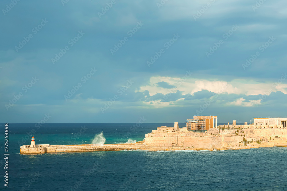 View of beautiful sea with lighthouse and cloudy sky