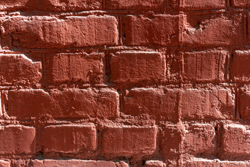 Red brick wall background. Close-up view of old painted red brick wall surface covered with cracks and scratches. Copy space for your text and decorations. Abstract backdrop theme.