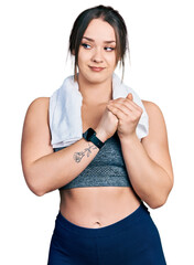 Wall Mural - Young hispanic girl wearing sportswear and towel laughing nervous and excited with hands on chin looking to the side