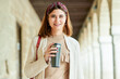 Woman walking down the street with reusable cup