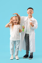 Wall Mural - Cute little kids in scientist's costumes measuring height on blue background