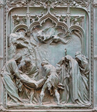 Fototapeta  - MILAN, ITALY - SEPTEMBER 16, 2024: The detail from main bronze gate of the Cathedral -   Burial of Jesus in the temple -  by Ludovico Pogliaghi (1906).