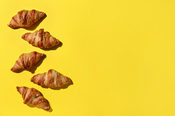 Wall Mural - Many tasty croissants on yellow background