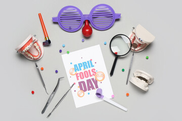 Sticker - Card with text APRIL FOOLS DAY, dentist's tools and party decor on grey background