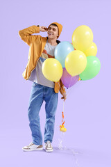 Sticker - Young man in casual attire with bunch of colorful balloons on lilac background