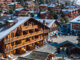 Fototapeta  - Aerial panoramic view of the Verbier ski resort town in Switzerland. Classic wooden chalet houses standing in front of the mountains. 