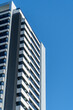 © ADDICTIVE STOCK - Striking image of a modern high-rise building with white and black patterns, standing under a clear blue sky in Madrid, Spain