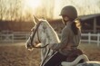 Young rider on horseback during golden hour at equestrian center