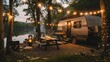 Travel trailer parked by the lake with outdoor seating and garlands. The setting sun colors its sleek exterior with warm hues, creating an atmosphere for outdoor relaxation.