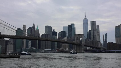 Wall Mural - boats passing under the brooklyn bridge with view of nyc skyline (sunset new york city east river) waterfront harbor historic landmark travel tourism destination downtown