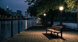 Fototapeta Miasto - Bench on the bank of the river in the evening, illuminated by street lamps