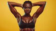 Black fitness girl in powerful dynamic posture against a yellow background. Concept for wellness campaigns and motivational content.