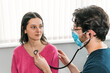 © ADDICTIVE STOCK - A doctor attentively uses a stethoscope on a young female patient, a key step in a comprehensive cardiac assessment