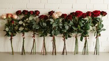   A Row Of Red And White Roses On A White Brick Wall, In Front Of A Row Of Green And Red Roses On Another White Brick Wall, And Behind A Row Of Red And White