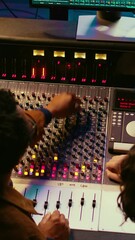 Fototapete - Vertical Video Music production team examining volume levels on audio software, using mixing and mastering techniques to create a hit song. Musician and sound designer work on editing recorded tracks