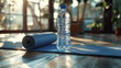 Close-up of a bottle water and yoga mat on wooden floor