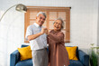 Asian active senior couple enjoy dance together in living room at home. 