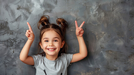 Wall Mural - cute little girl holding point up, smiling kid, cute, peace sign