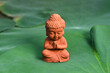 Close-up of Buddha Statue on green leaf