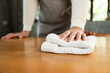 © Chanakon - Housewife with apron ready to clean home. Young woman is happy to clean home. Maid cleaning service. Spraying antibacterial sanitizing spray wipe with towel