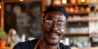 New generation expressing yourself concept. Portrait of happy modern handsome stylish adult African American hipster man with handlebar moustache and beard looking into camera sitting in cafe