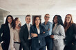 © Flamingo Images - Smiling group of diverse businesswoman standing together in a boardroom. They are all wearing suits in different colors