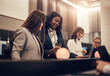 © Flamingo Images - Smiling businesswomen working together in a hotel lobby during a trip