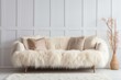 comfy sofa with beige furry sheepskin cover and pillows against the wall