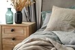Soft grey hues and natural textures define a boho-modern bedroom, with a wooden nightstand and decorative vases.