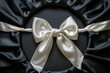 © Osama - White holiday round frame with bow and silky ribbon on black background.