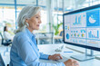 © Victor - Senior businesswoman working with financial graphs charts online in office using business software for data analysis and project management concept. Mature female employee working on financial report.